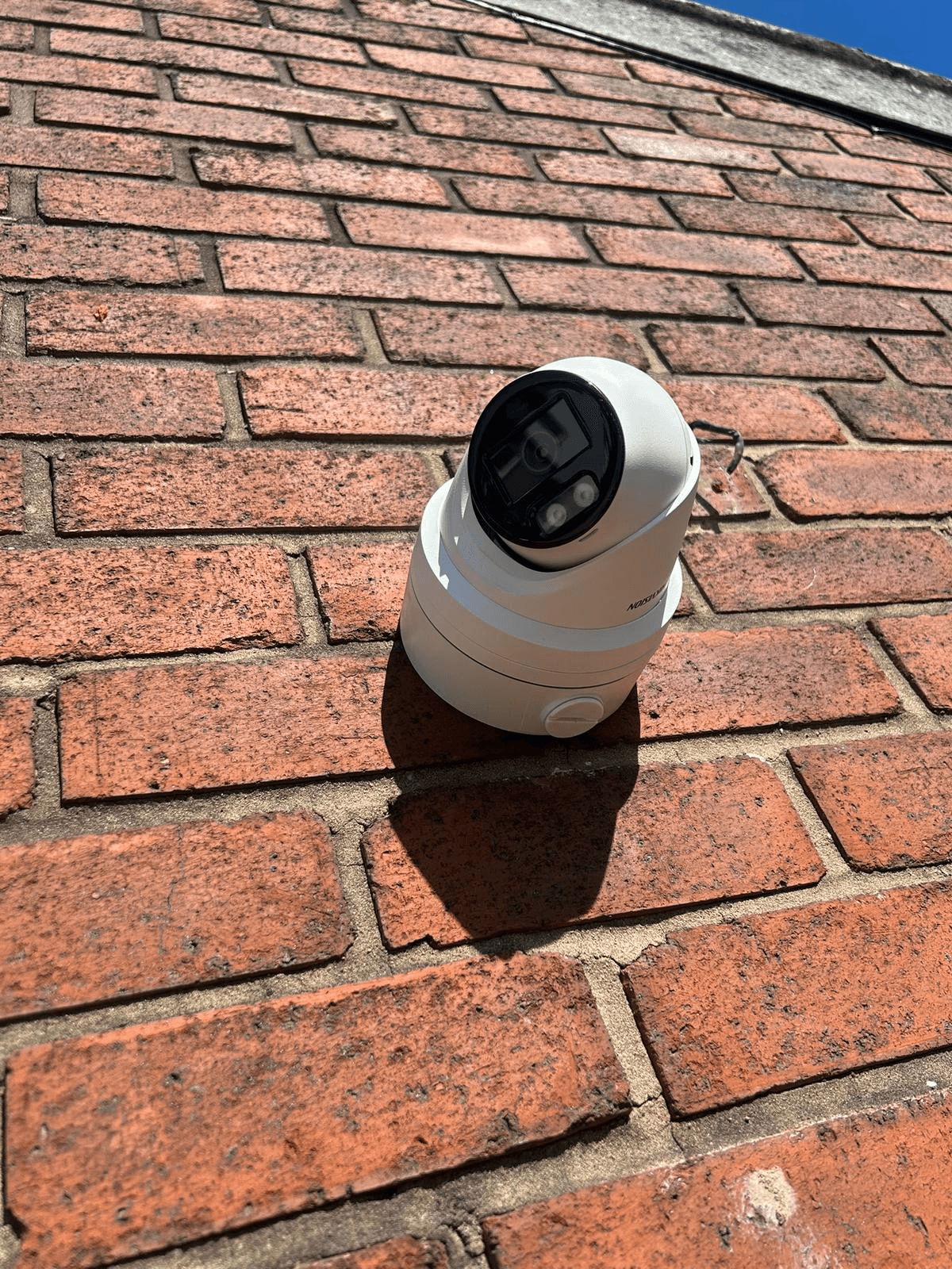 CCTV security camera mounted on exterior brick wall