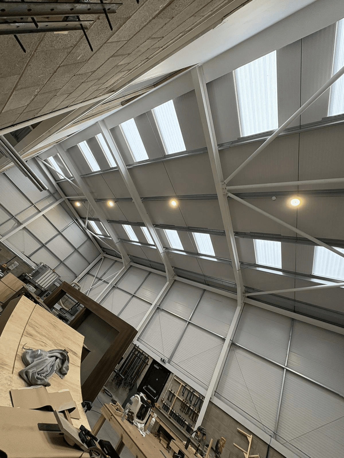 Large commercial workshop with industrial LED lighting installed across high steel roof structure