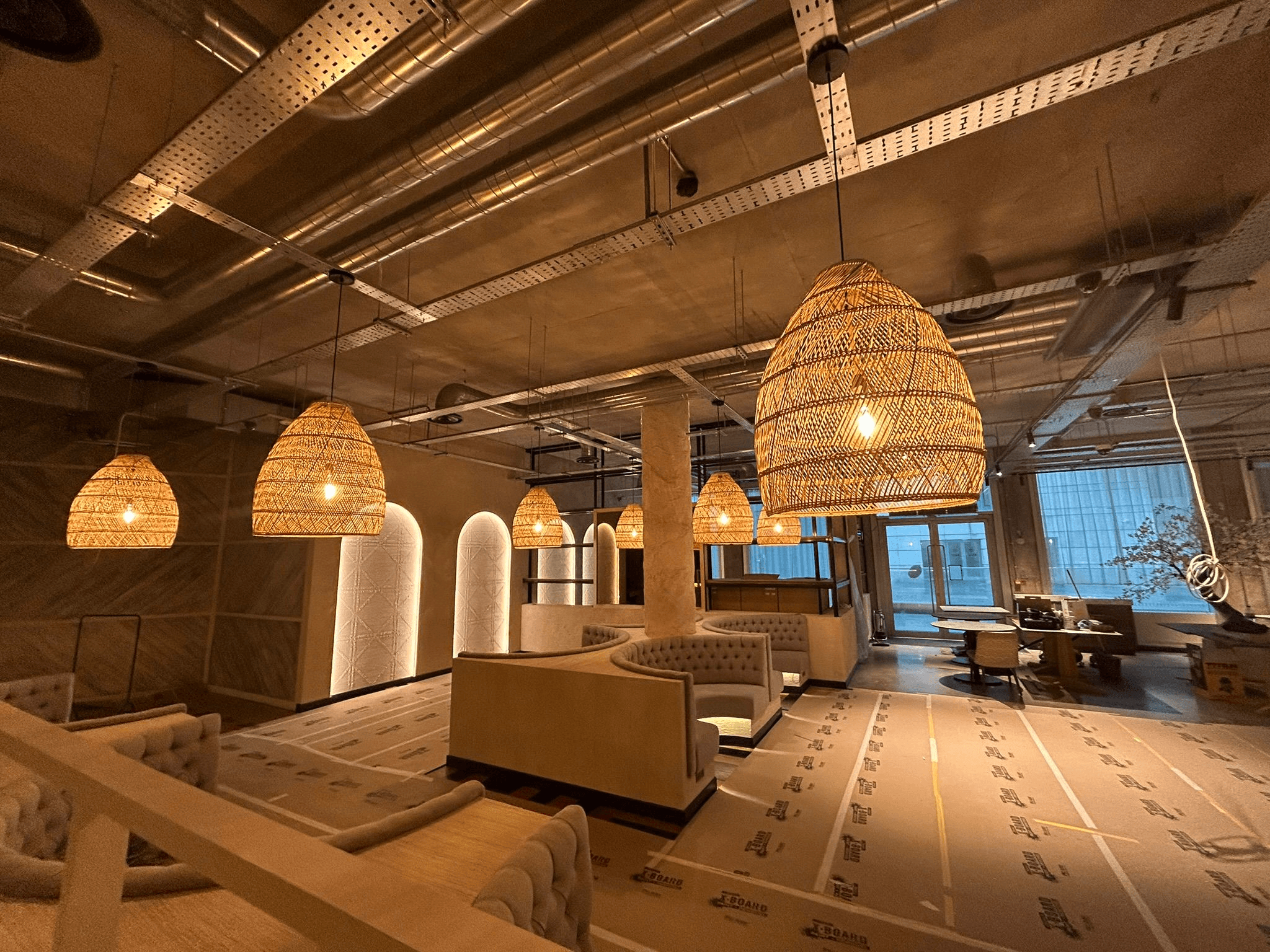 Commercial bar and lounge space with wicker pendant lighting and arched feature walls