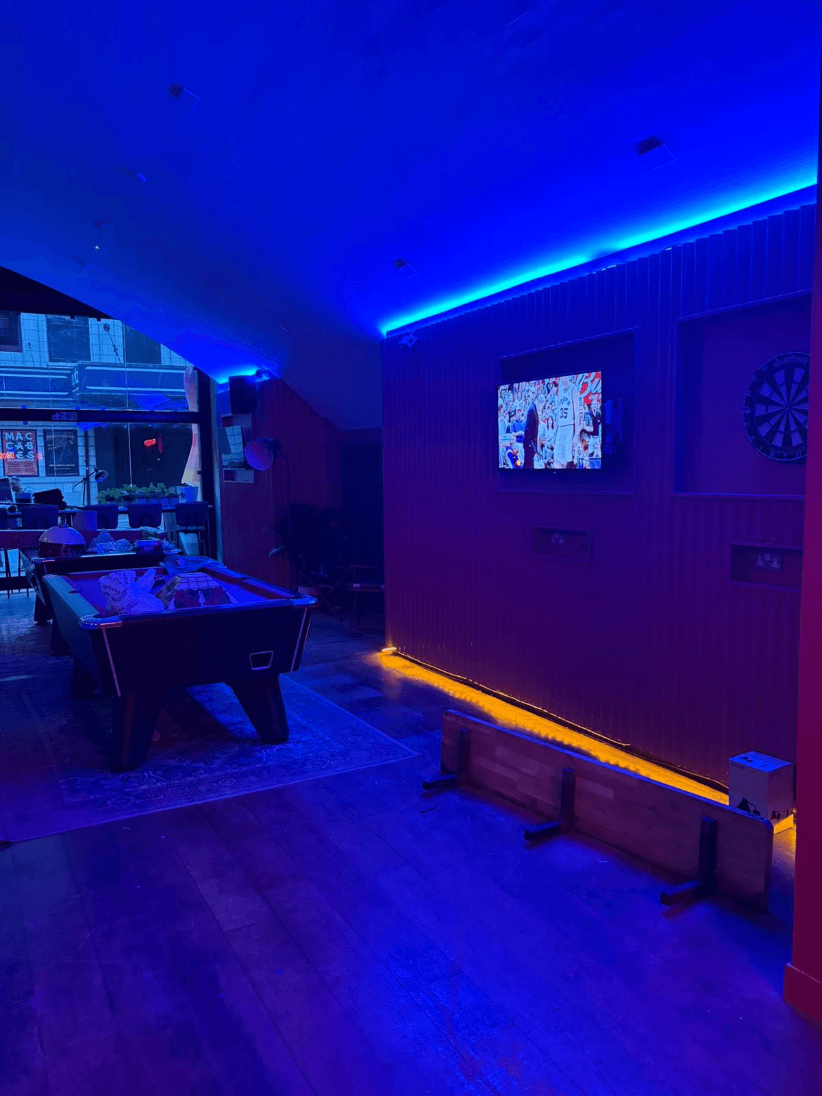 Games room with blue and amber LED strip lighting around ceiling and bar area