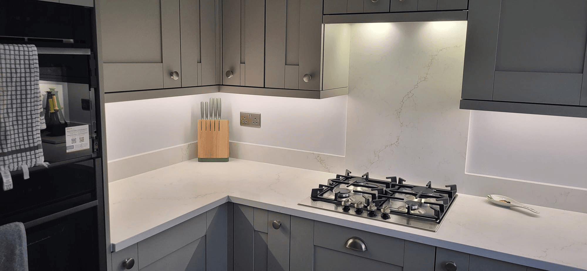 Under-cabinet LED lighting in modern grey kitchen