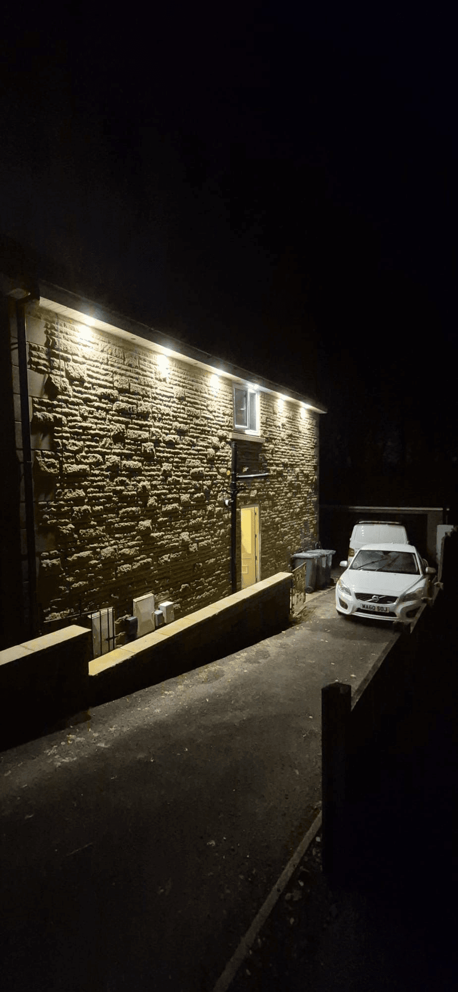 Outdoor wall lighting installation on stone building